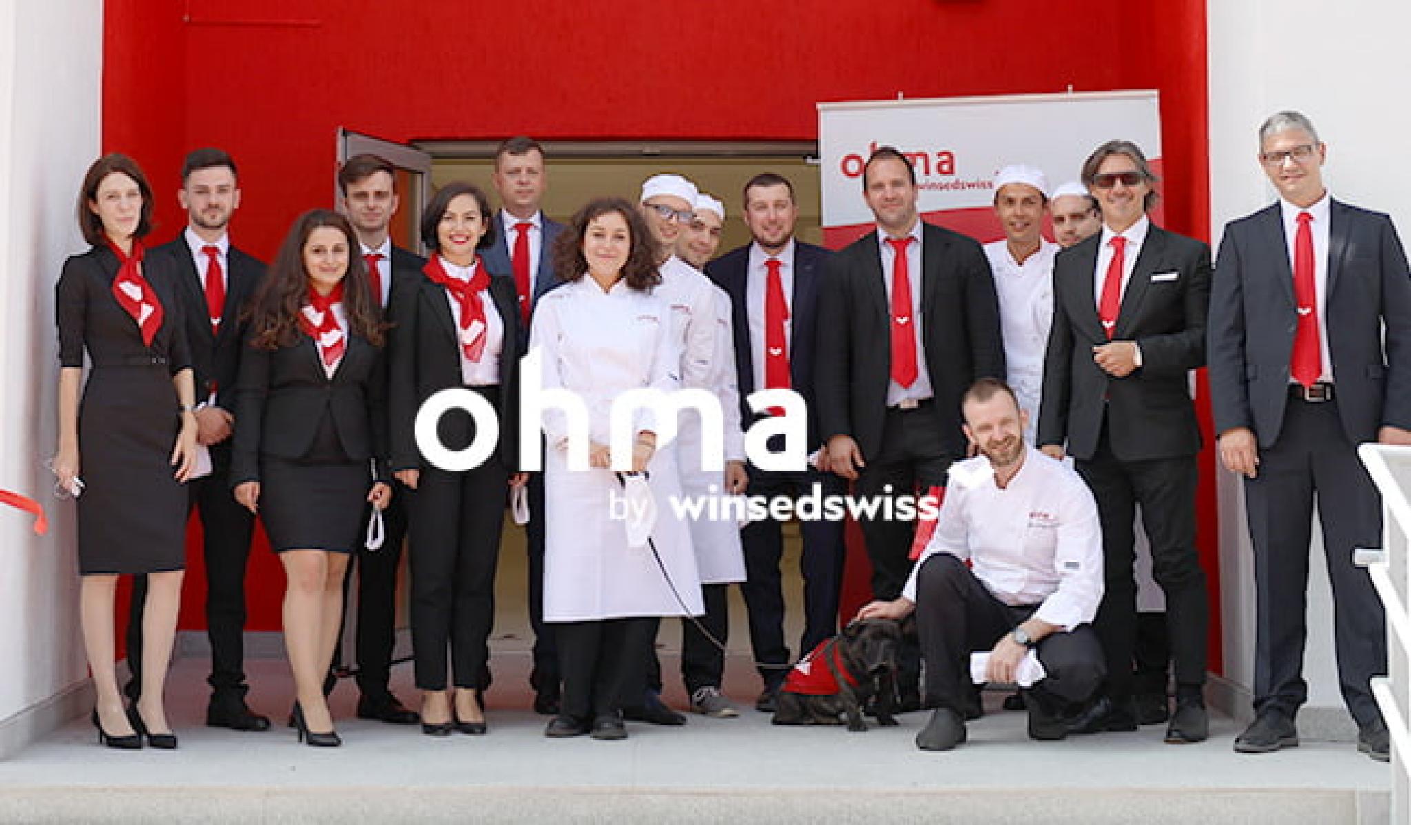 Picture of ohma team members in front of the school